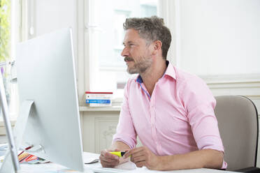 Geschäftsmann konzentriert sich bei der Arbeit am Computer im Büro - FKF03918