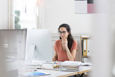 Female professional smiling while using computer in office - FKF03921