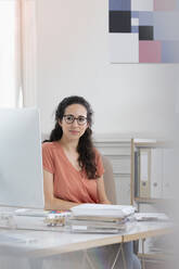 Businesswoman working at desk in office - FKF03922