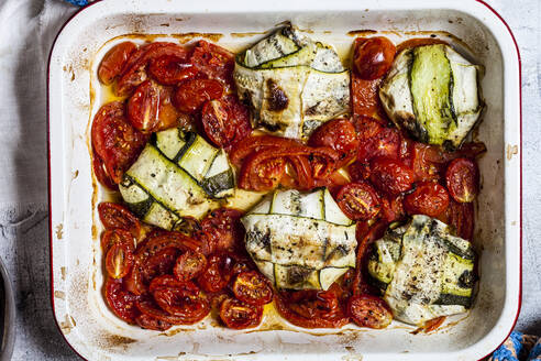 Gegrillte Tomaten mit Spinat und Feta-Käse gefüllte Zucchini-Ravioli in einem Teller auf dem Tisch - SBDF04455