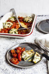 Mit Spinat und Fetakäse gefüllte Zucchini-Ravioli mit gegrillter Tomate auf dem Tisch - SBDF04458