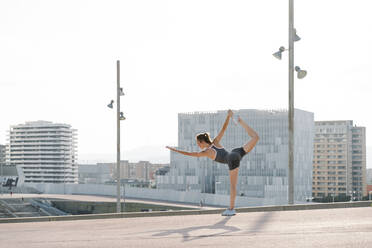 Mid adult sportswoman doing yoga pose on a sunny day - RDGF00287