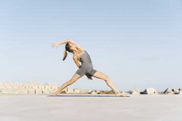 Mittlere erwachsene Sportlerin beim Yoga auf der Übungsmatte - RDGF00299