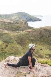 Junger Mann beim Yoga in der Natur auf einem Berg in Santander, Spanien - JAQF00012