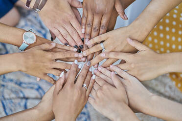 Detail of a group of multiracial friends joining hands in a park - CAVF91391