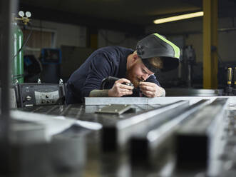 Metalltechniker bei der Prüfung von Material während der Arbeit im Werk - CVF01635