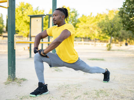 Sportler streckt sein Bein beim Sport im Park - JCCMF00156