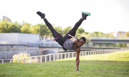 Lächelnder Sportler, der im Freien einen Handstand macht - JCCMF00186