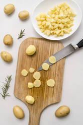 Studio shot of kitchen knife and chopped potatoes on cutting board - MAUF03655