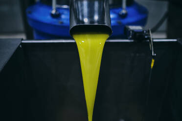 Nahaufnahme einer gelben chemischen Flüssigkeit, die aus einem Metallhahn im Industriegebiet einer modernen Fabrik fließt - ADSF19004