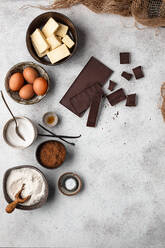 Draufsicht auf verschiedene Zutaten für ein traditionelles Brownie-Kuchenrezept, angeordnet auf einem grauen Marmortisch - ADSF19014