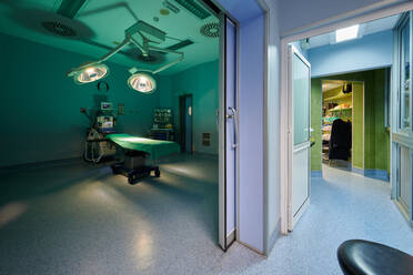 Zeitgenössische Operationssaal Interieur mit Couch unter glänzenden Lampen in der Nähe von professionellen Geräten im Krankenhaus - ADSF19031