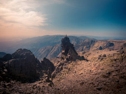 Anonymer Reisender auf borstigem Berg, der das Hochland unter hellem Himmel während einer Sommerreise in Spanien bewundert - ADSF19143