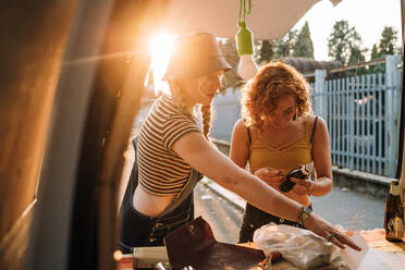 Young women at the back of their van - CUF56605