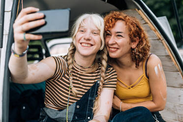 Lesbisches Paar lächelt und macht ein Selfie - CUF56611