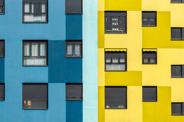 Background of blue and yellow exterior of residential building with windows of various sizes in city - ADSF19196