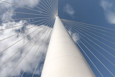 Von unten der weißen modernen Hängebrücke mit hoher Säule, die viele Kabel miteinander verbindet, gegen den blauen Himmel - ADSF19201