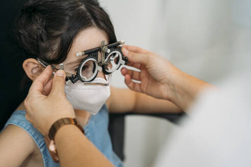 Optometristin beim Sehtest eines Patienten in der Klinik während COVID-19 - MPPF01312