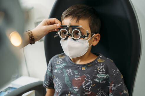 Junge mit Brille bei einem medizinischen Sehtest in der Klinik während COVID-19 - MPPF01313