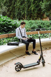 Young businessman working on laptop outdoors - XLGF00868