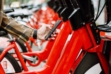 Mans Hand hält Smartphone, um Fahrrad zu mieten - XLGF00884