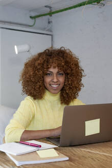 Smiling woman with laptop at home - VEGF03306