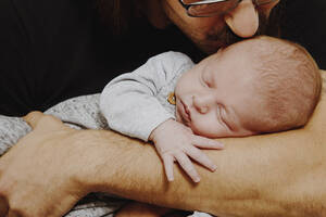 Vater küsst, während er seinen süßen Sohn im Studio auf dem Arm trägt - NGF00728