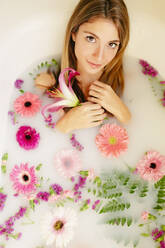 Junge Frau nimmt ein Milchbad im Badezimmer - GMLF00902
