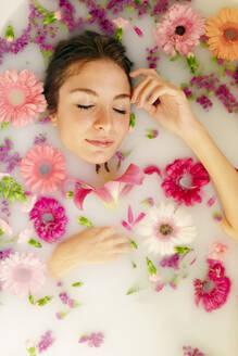 Young woman relaxing with eyes closed in bathtub at spa - GMLF00912