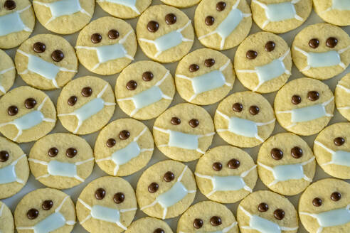 Rows of Christmas cookies with faces wearing protective face masks - ELF02307