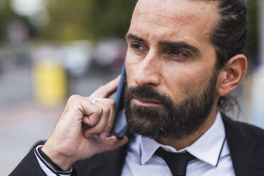 Portrait of bearded man talking on smart phone - JCCMF00218