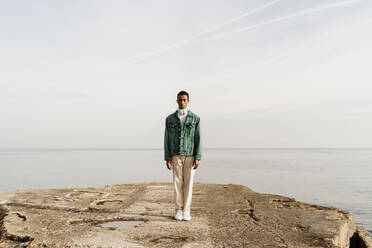 Young man standing on damaged pier against sky - AFVF07852