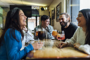 Lächelnde Freunde bei einem Drink im Restaurant - EGAF01276