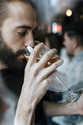 Junger Mann trinkt Bier in einer Bar - EGAF01287