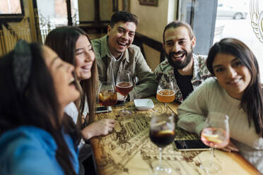 Männliche und weibliche Freunde lachen, während sie ein Selfie in einer Bar machen - EGAF01298