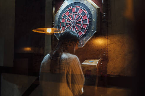 Junge Frau spielt Darts in einer Bar - EGAF01301