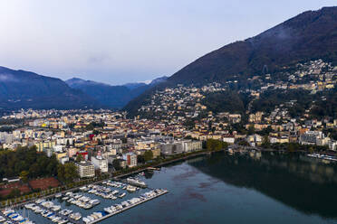 Schweiz, Kanton Tessin, Locarno, Blick aus dem Hubschrauber auf die Stadt am Ufer des Lago Maggiore in der Morgendämmerung - AMF08865