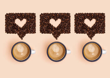Studioaufnahme von Kaffeebechern und gerösteten Kaffeebohnen, die in Form von Online-Chatblasen angeordnet sind - GEMF04462