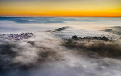 Germany, Baden-Wurttemberg, Berglen, Drone view of village shrouded in thick fog at dawn - STSF02734