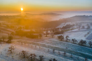 Germany, Baden-Wurttemberg, Berglen, Drone view of countryside fields at foggy autumn sunrise - STSF02741