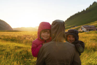 Smiling children with their mother at sunset during vacations at Col Des Aravis, Haute-savoie, France - GEMF04476