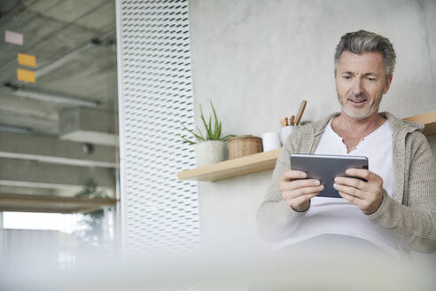 Lächelnder Mann mit digitalem Tablet - FMKF06923