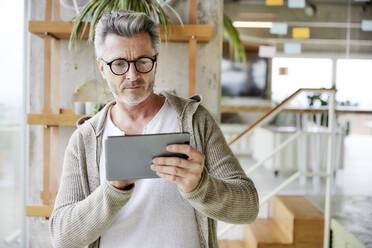 Älterer Mann mit Brille und digitalem Tablet - FMKF06930