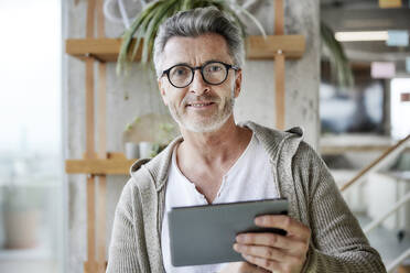 Mann mit Brille und digitalem Tablet - FMKF06932