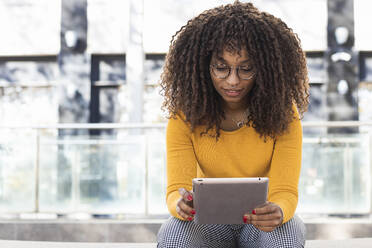 Junge Frau benutzt digitales Tablet im Freien - PNAF00269