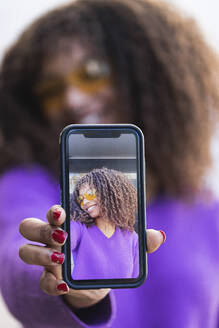 Afro-Frau zeigt Selfie durch Mobiltelefon - PNAF00292