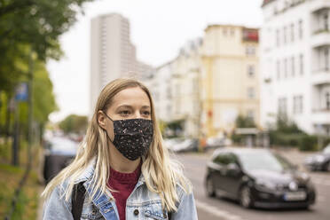 Junge Frau mit Gesichtsschutzmaske in der Stadt - BFRF02349