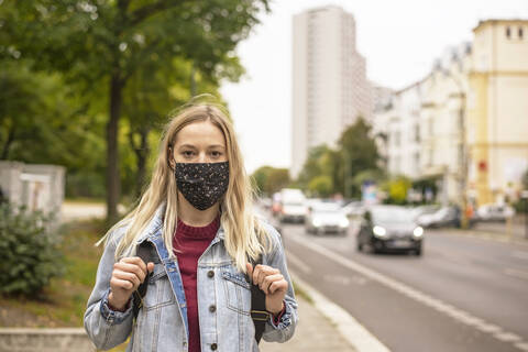 Woman with protective face mask in city during COVID-19 stock photo