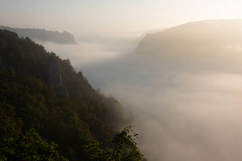 Danube Valley in Swabian Alb mountain during foggy weather at sunset, Germany stock photo