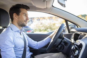 Männlicher Unternehmer sitzt im Auto an einem sonnigen Tag - IFRF00188